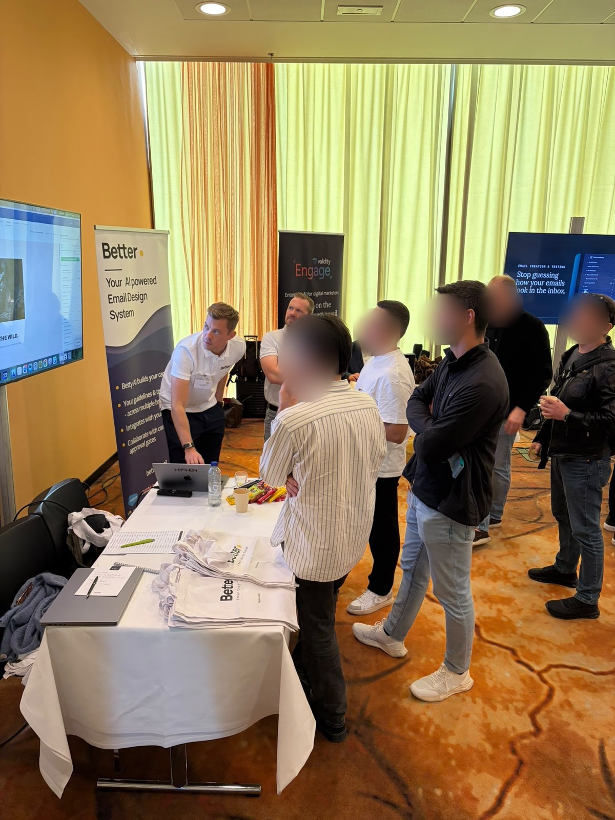 A group of conference attendees watching Simon demo Better Email on the booth screen